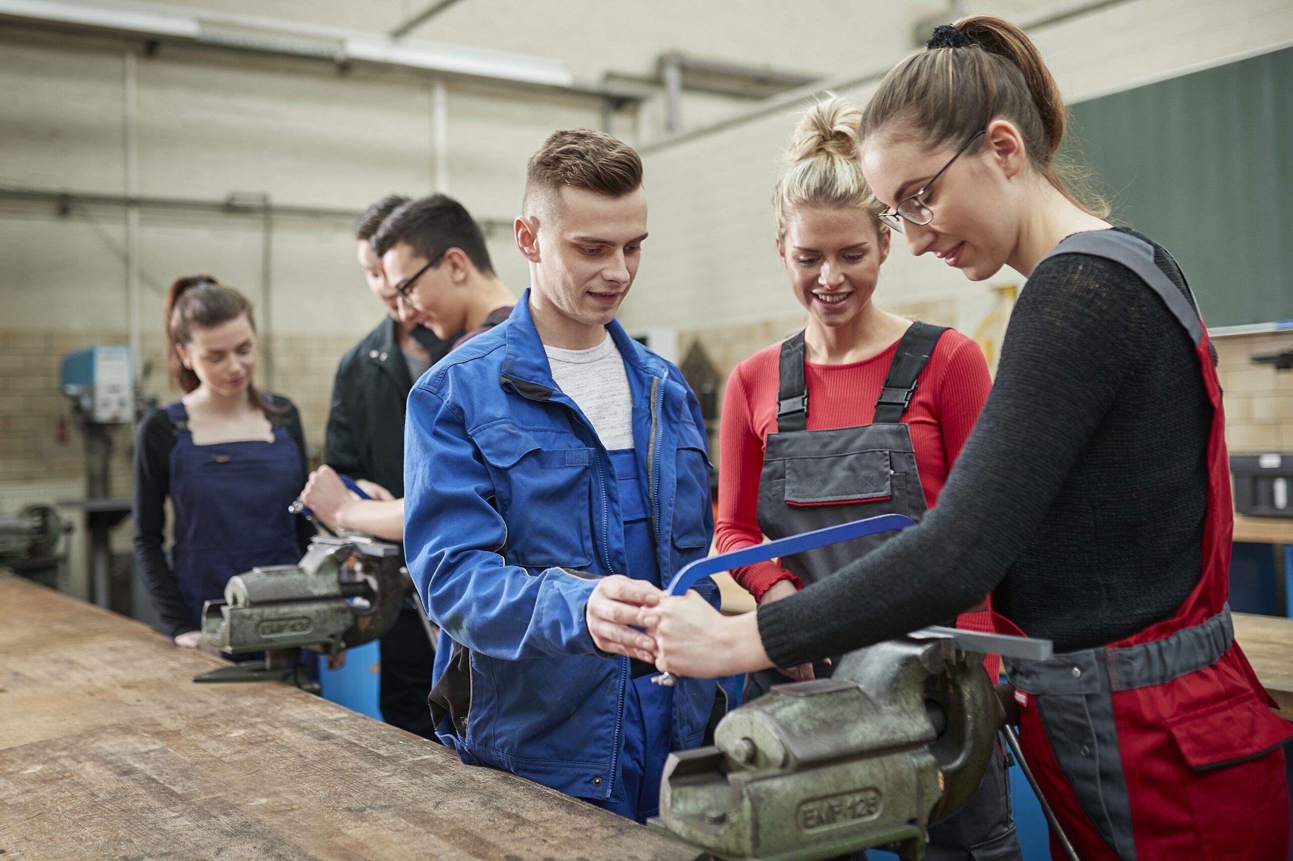 Auszubildende arbeiten an einem Metallstück
