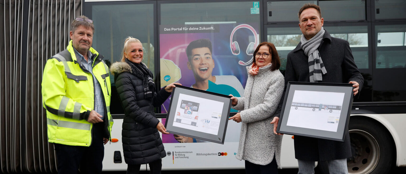 Führungskräfte der HWK und IHK Halle halten Plakate und stehen vor einem Bus