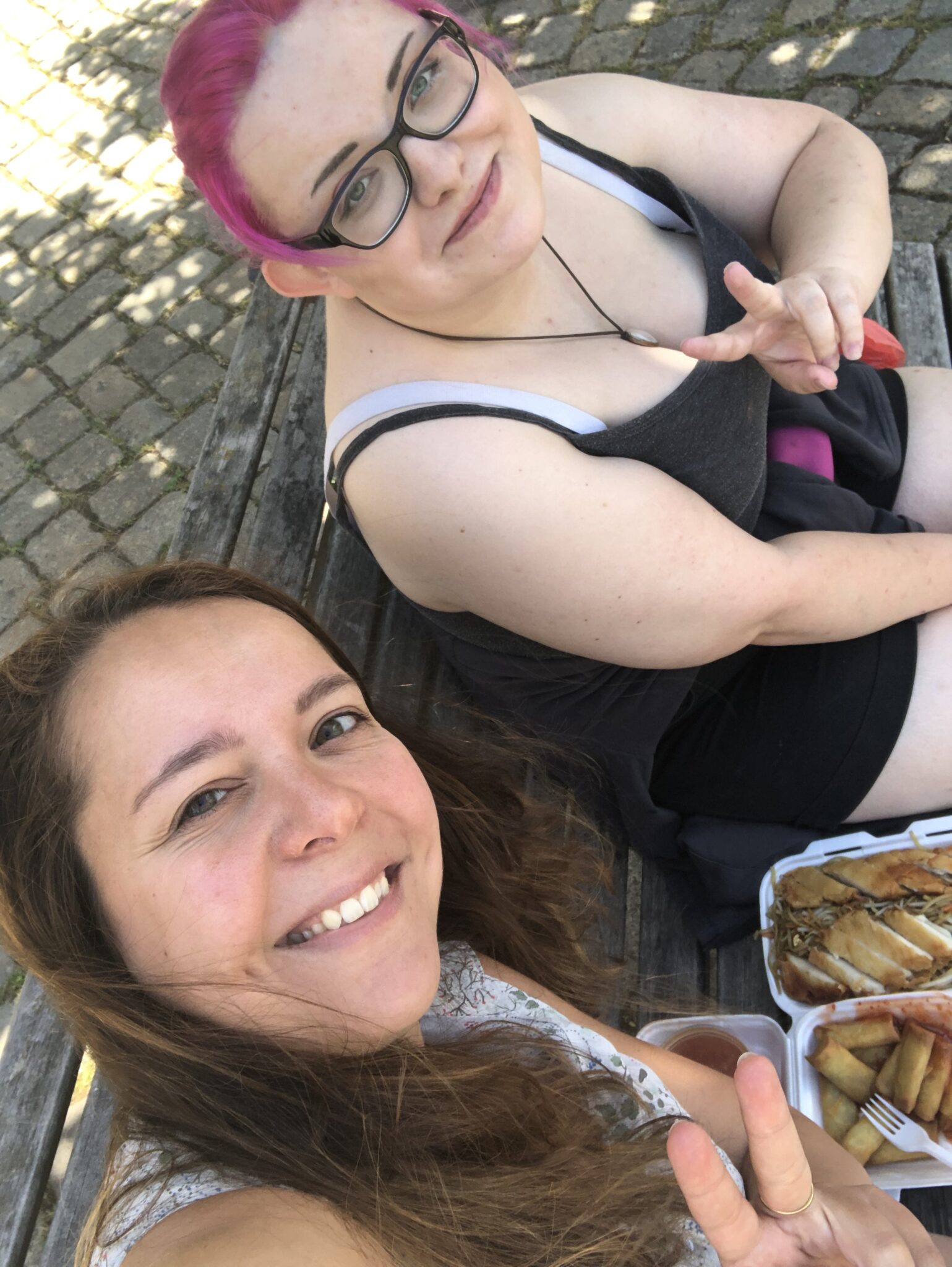 2 Frauen machen ein zusammen Selfie, lachen und zeigen Peace