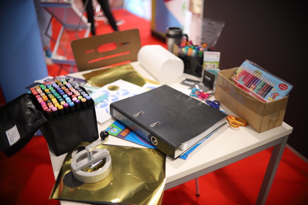 Bastelmaterial mit bunten Stiften und Glitzerfolie